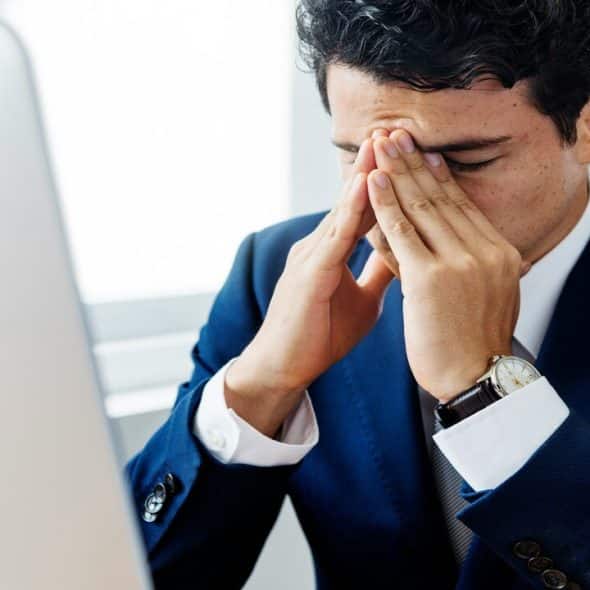 A man looking frustrated at work.