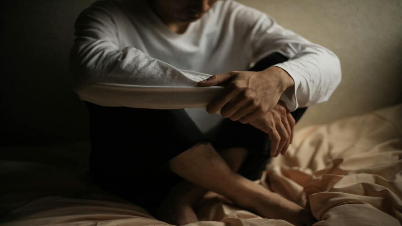 A man sad and alone in bed.