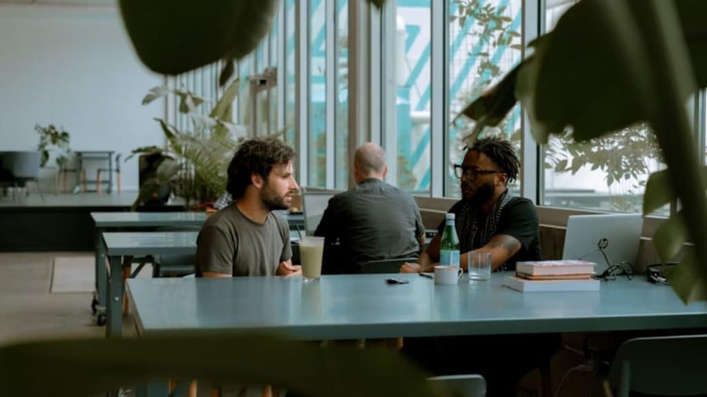 Men connecting through honest conversation in a cafe