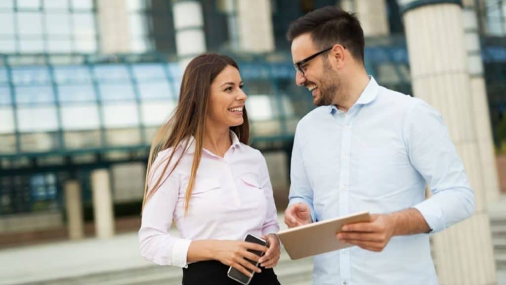 A candid photo of a woman smiling warmly during a casual outdoor conversation