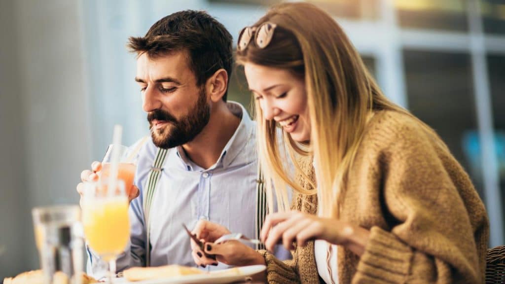 A couple enjoying a meal and drinks together.