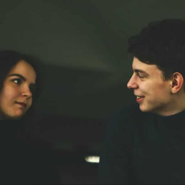 A man and woman looking at each other.