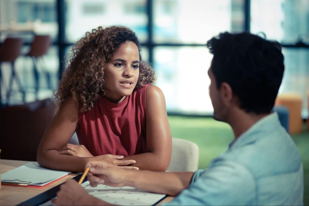 A woman looking serious and a man listening to her