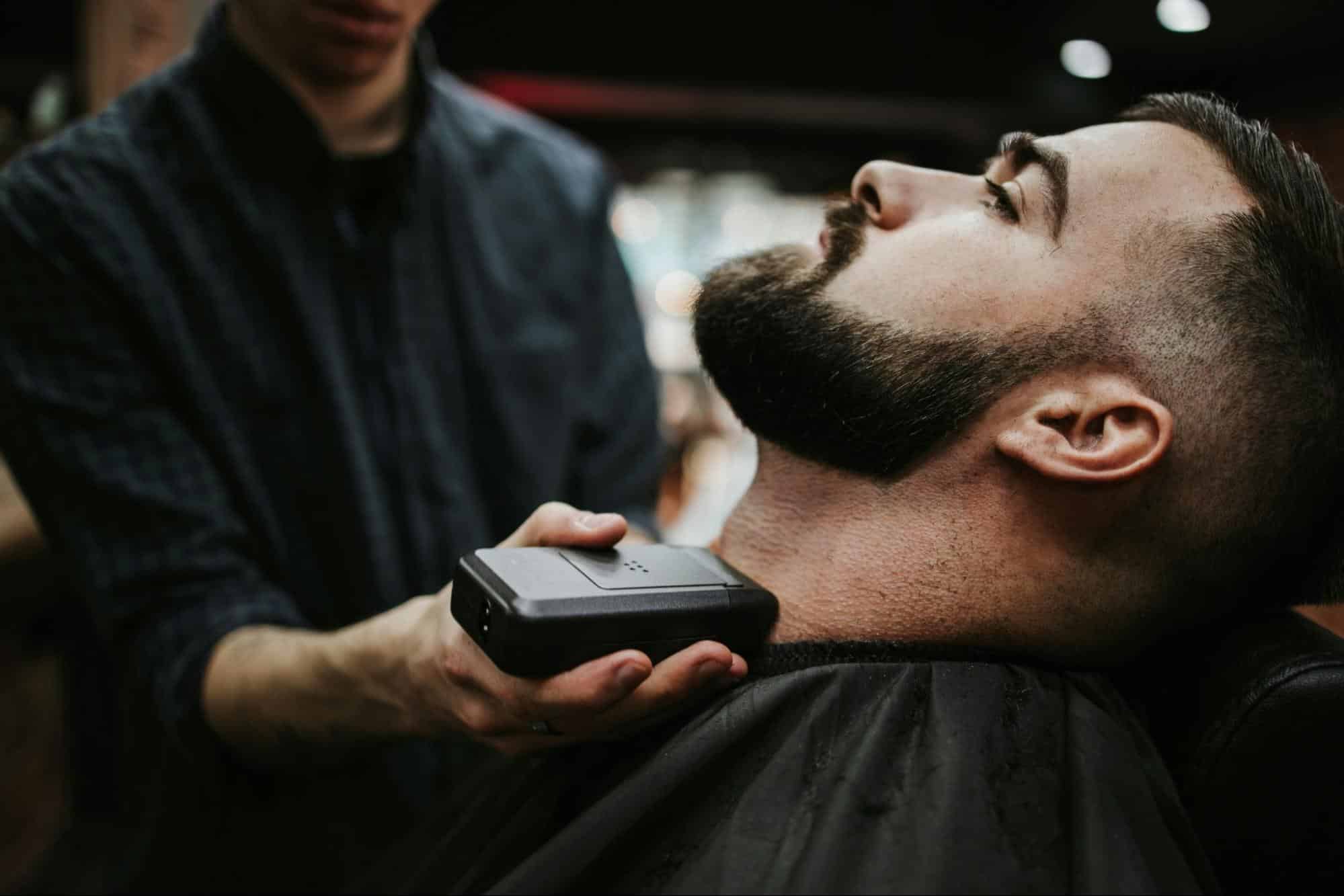 A man having his beard trimmed.