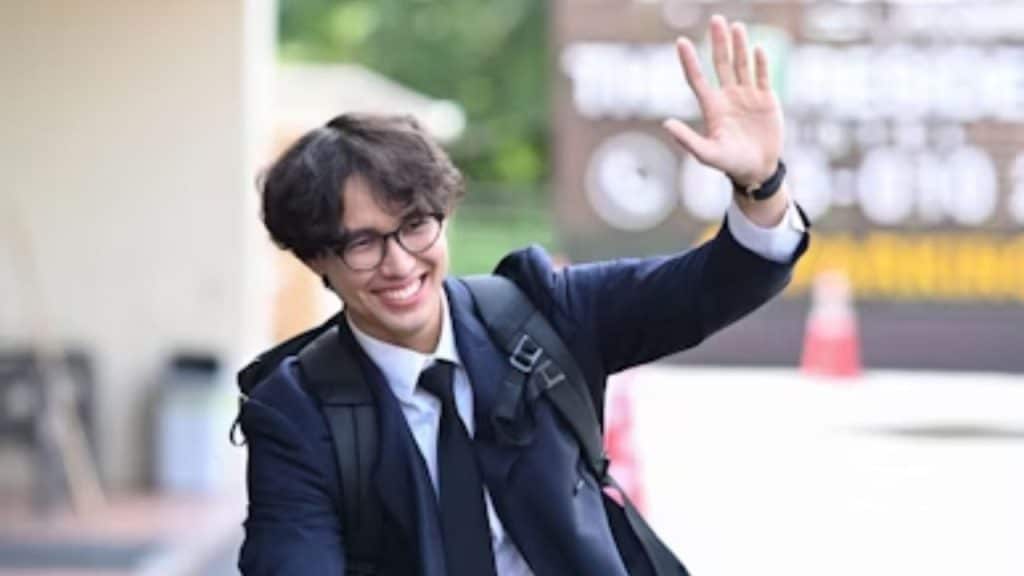 A man exiting a conversation with a polite smile and wave