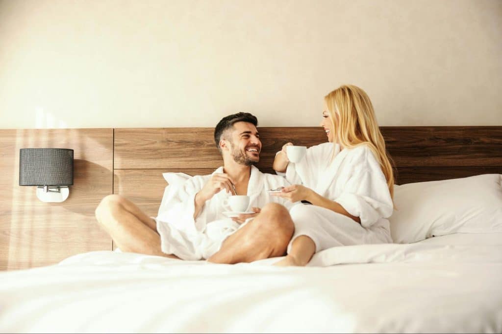 A man and woman sitting at the bed.
