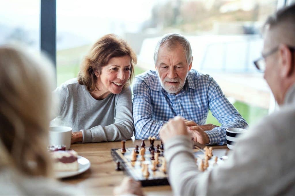 A man and woman happily playing a chess game together