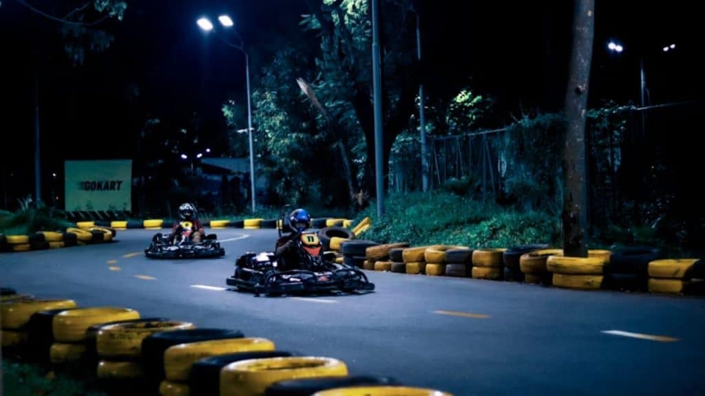 Couple racing each other on go karts, reconnecting through playful competition.