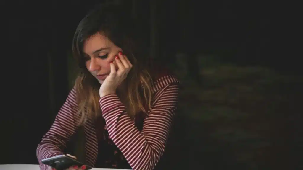 Woman looking disappointed while reading a short reply.