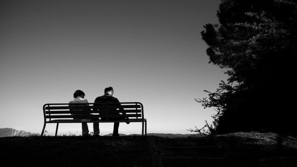 A couple sitting on a bench together