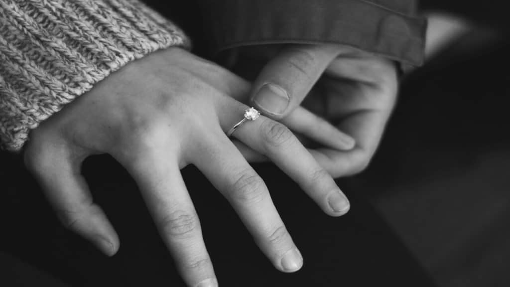 A man holding his fiancee’s engagement ring