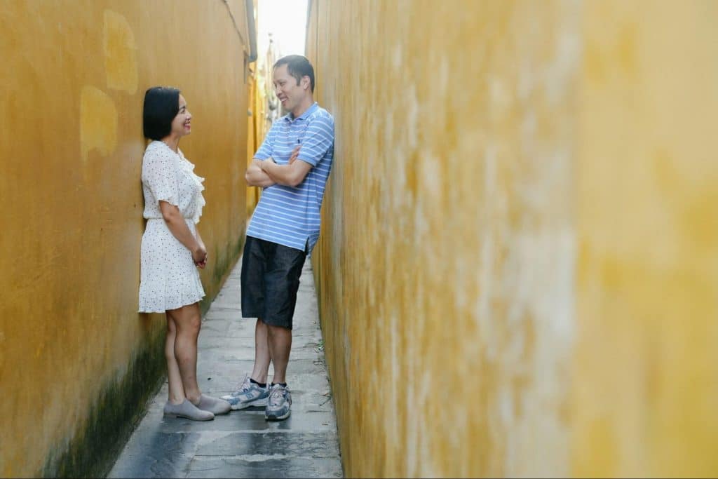 A man and woman standing in a narrow alley
