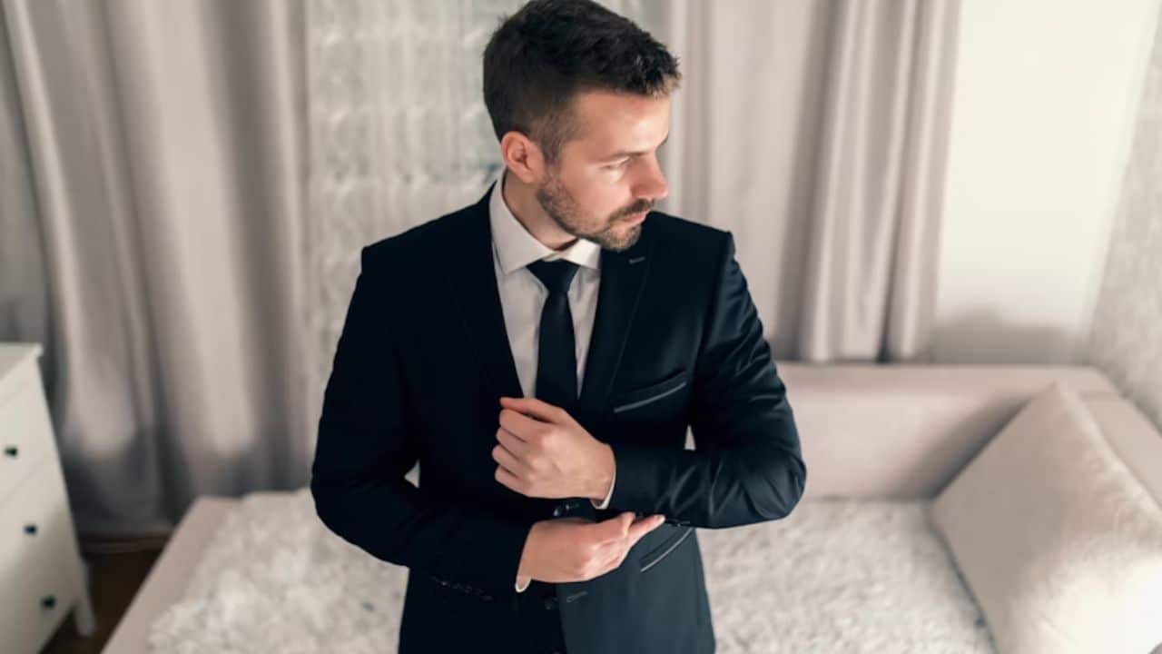 A man confidently tying cufflinks on jacket  feeling renewed.