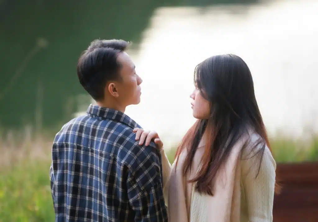 A woman holding a man’s shoulder.