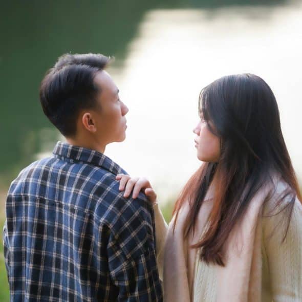 A woman holding a man’s shoulder.