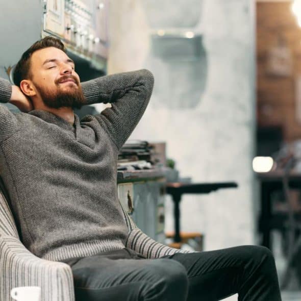A bearded man leaning back in a chair.
