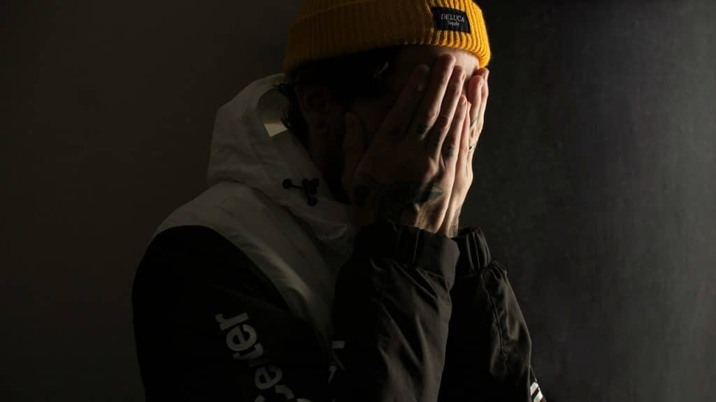 A man covering his face with both hands.