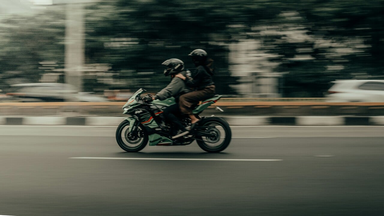 A couple riding a motorcycle together.