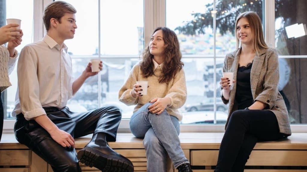 Woman focusing on one man’s words and reacting positively, even in a group setting