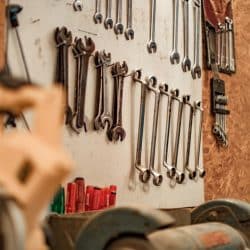 A row of metal wrenches hanging on a workshop board.