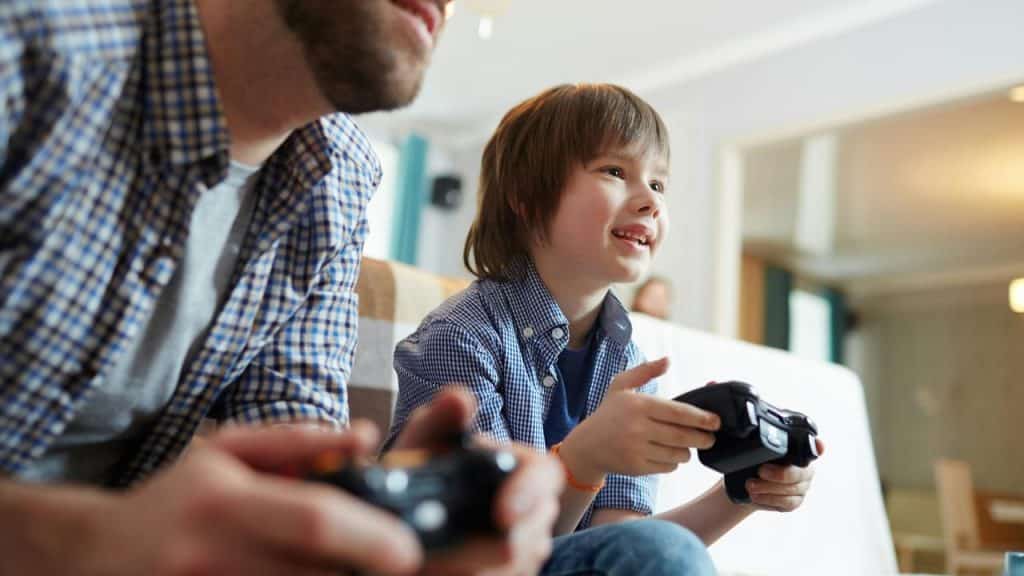 A father and son playing video games with controllers.