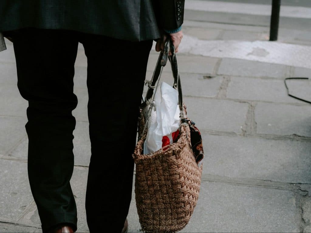 A man carrying  woman’s bag