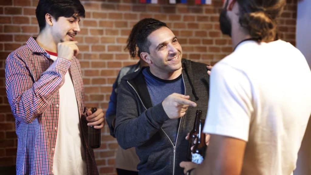 Man smiling while sharing kind words about his partner with others