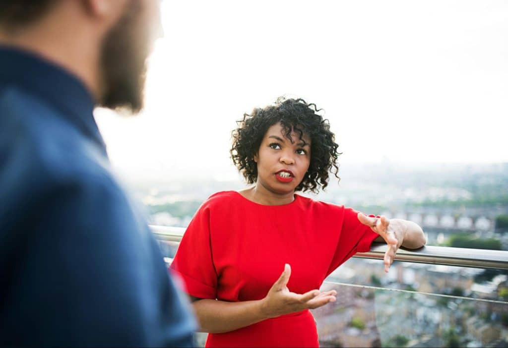 A man and woman talking while at the rooftop