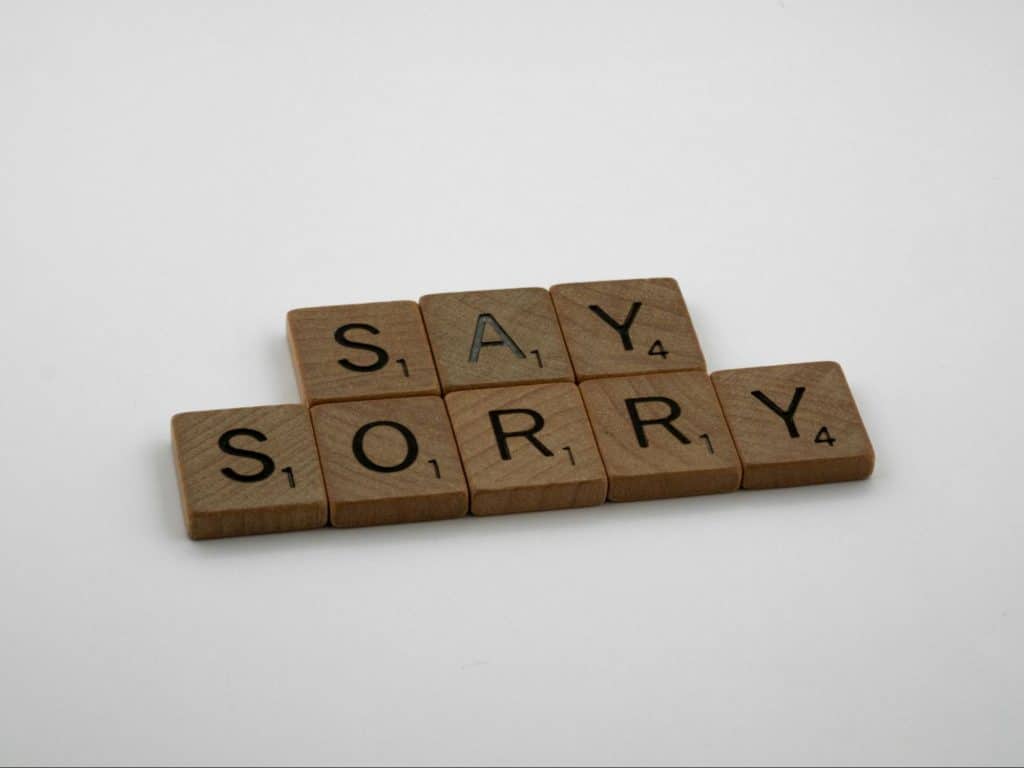 A scrabble words that says “say sorry”.