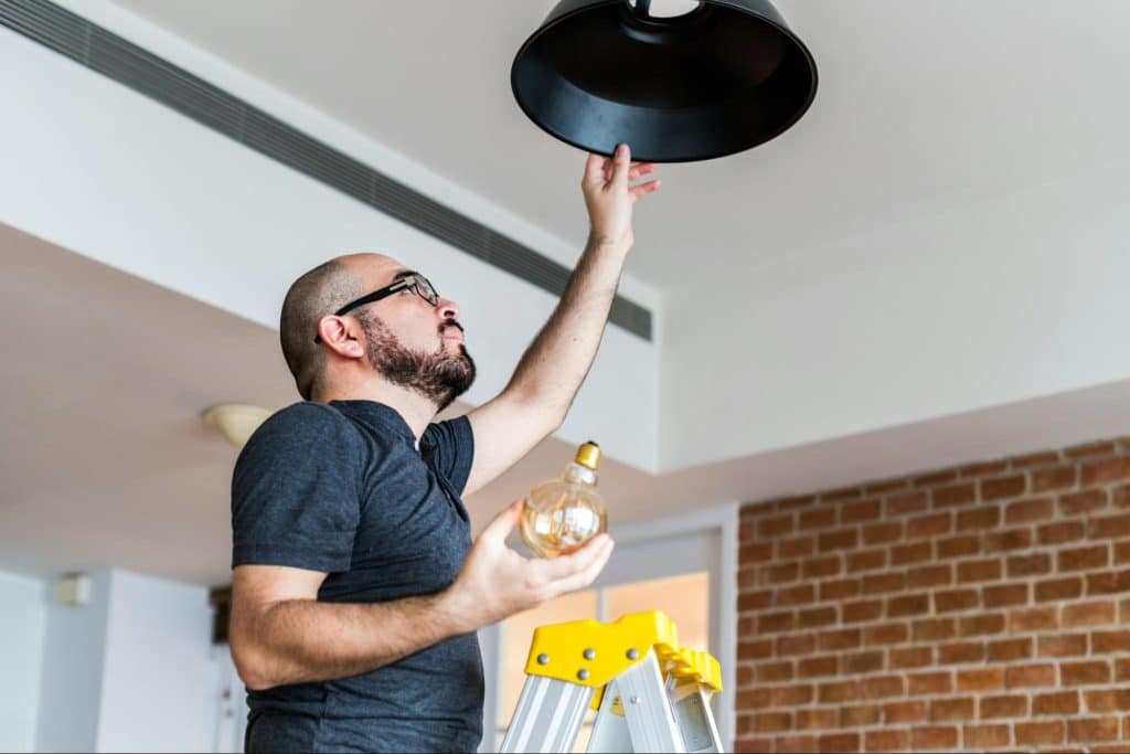 A man replacing a lightbulb