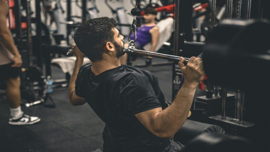 A man lifting at a busy gym