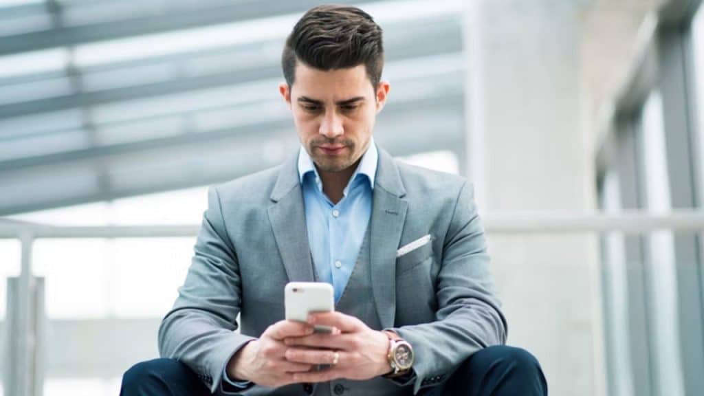 Man rereading a message on his phone with focus.