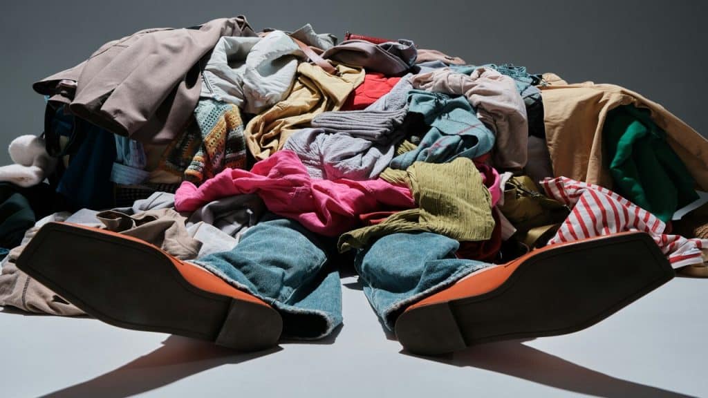 A person buried in a pile of clothes