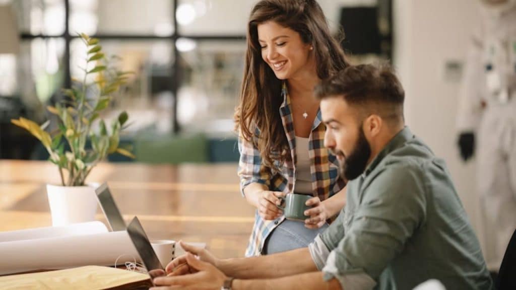 Man and woman adjusting their monthly budget using digital tools.