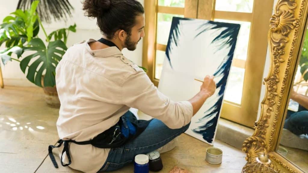 Man switching from work to painting at home.