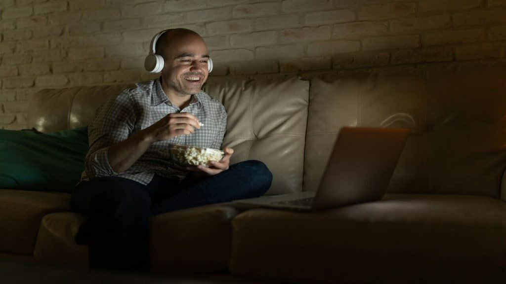 A man having popcorn while watching a movie