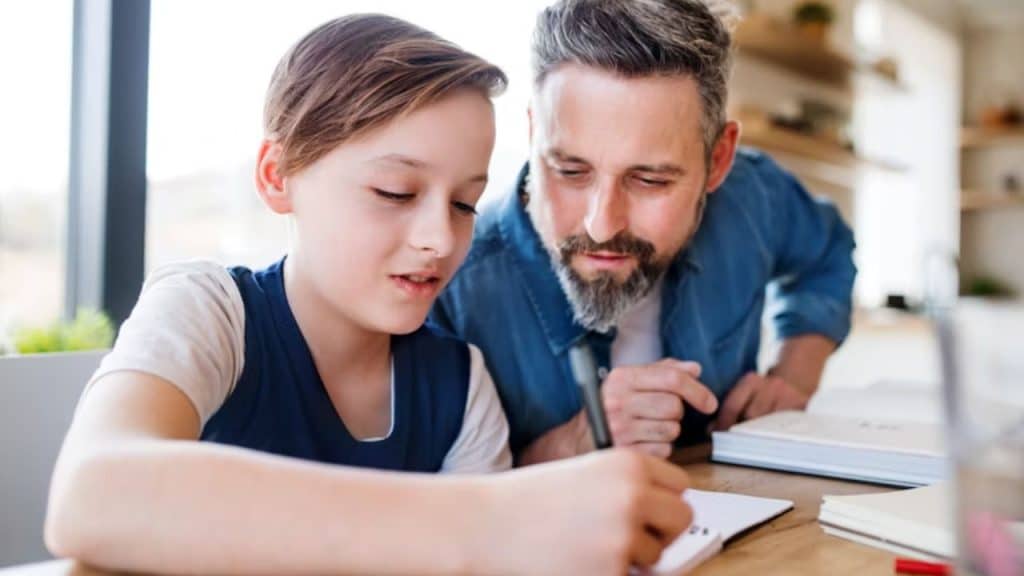Father teaching teen financial skills through hands on support