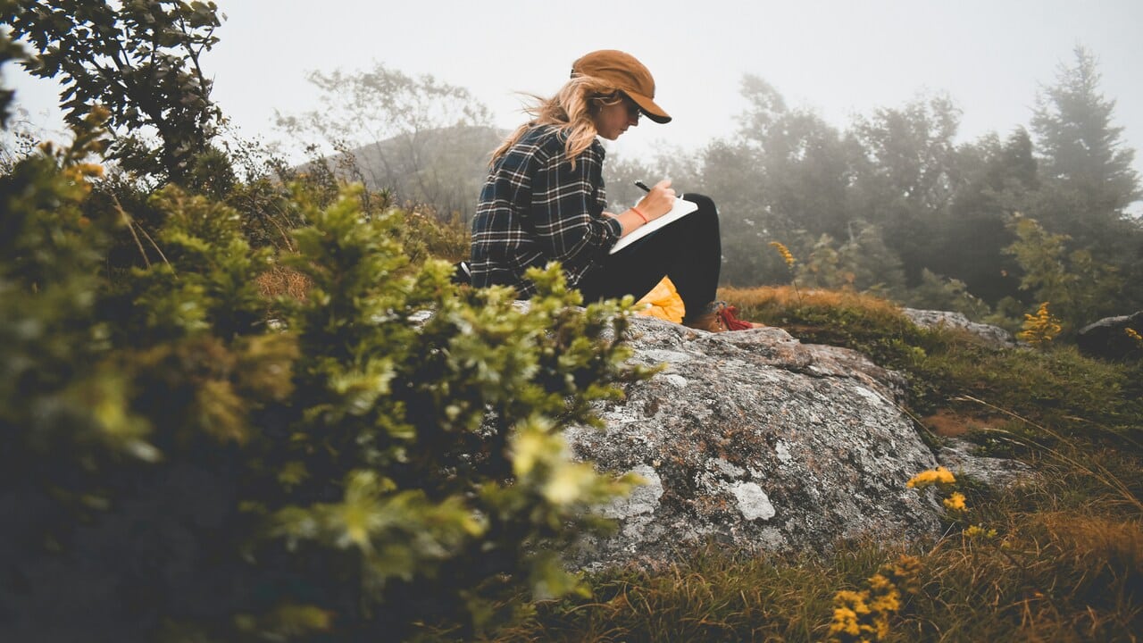 A woman journaling outdoors.