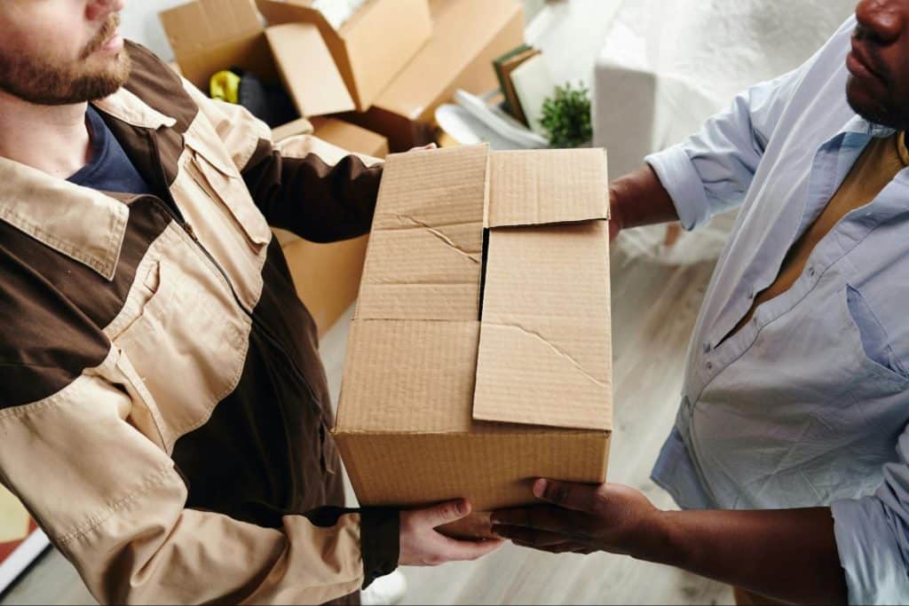 A man giving a package to another man.