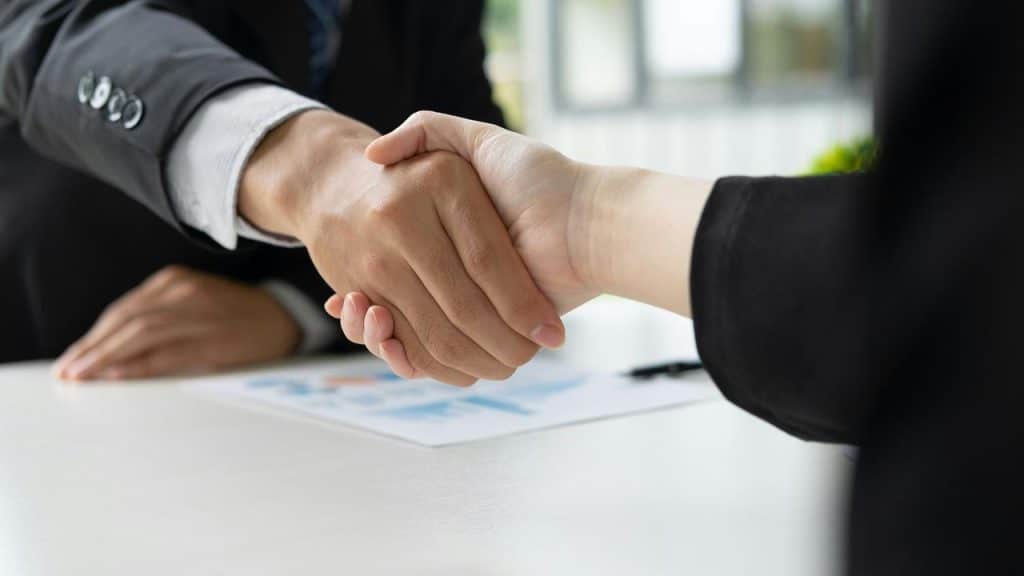 A close-up of two people in business attire shaking hands.