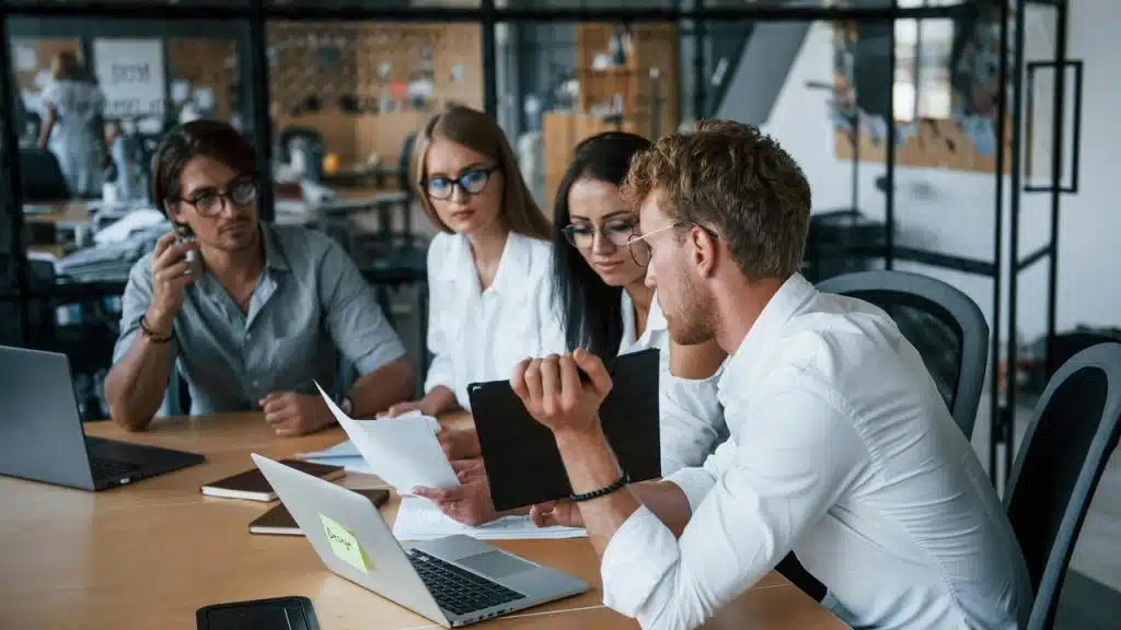 A group of coworkers collaborating over a laptop.