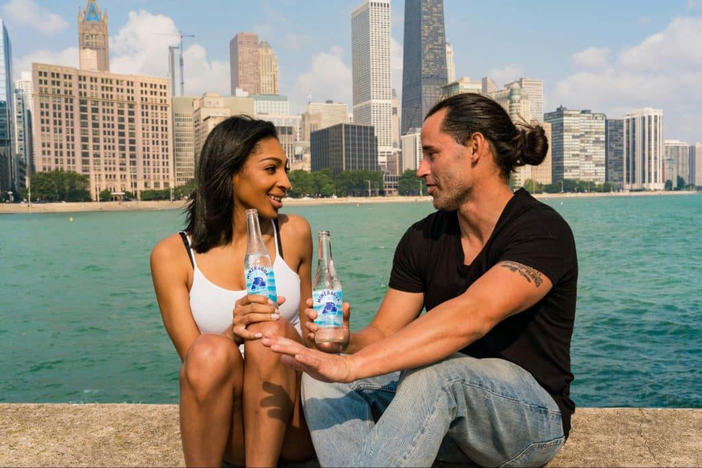 A man and woman drinking a sparkling water