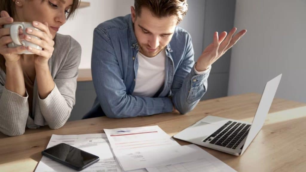 Man reviewing his budget while declining a costly suggestion.