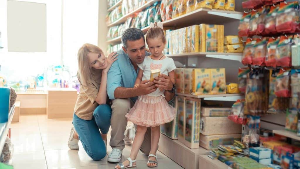A family examining a box in a grocery store aisle.