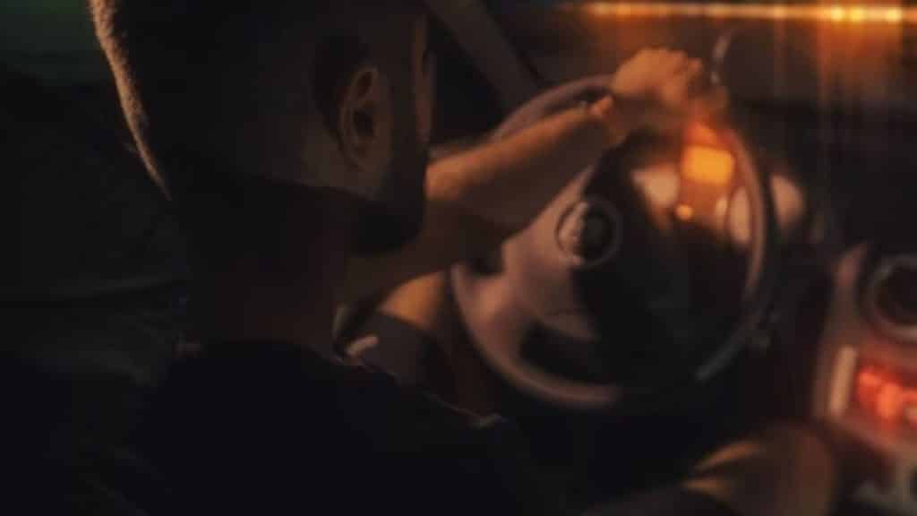 Man in a car lowering music to focus on road directions