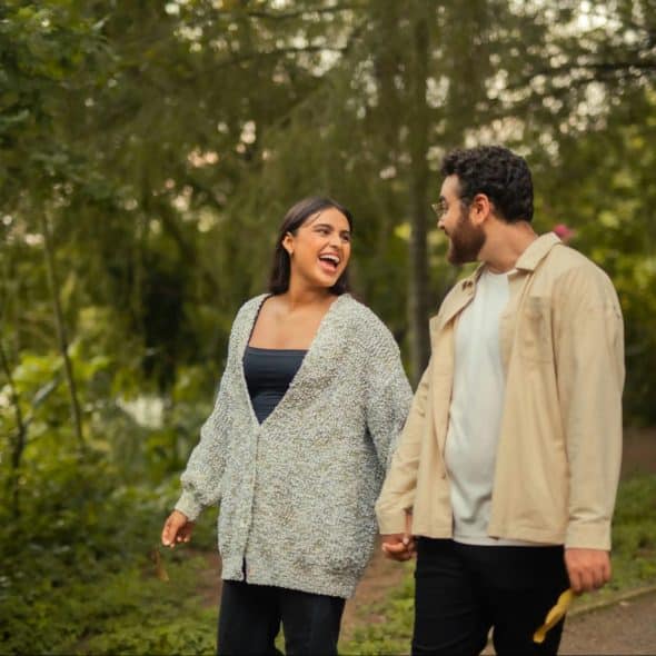 A man and woman walking outside while holding hands