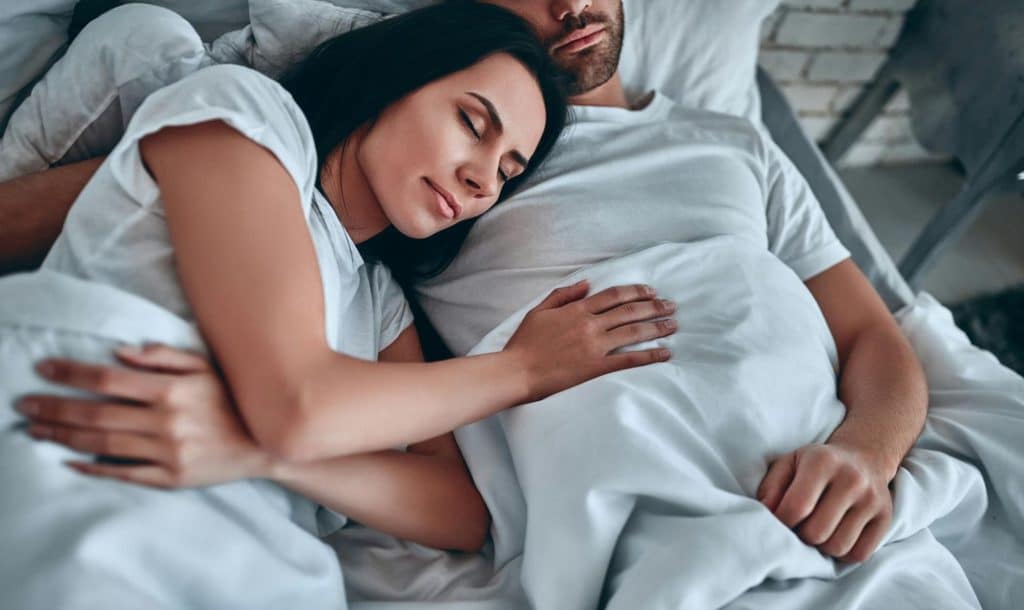 A woman laying on a man’s chest