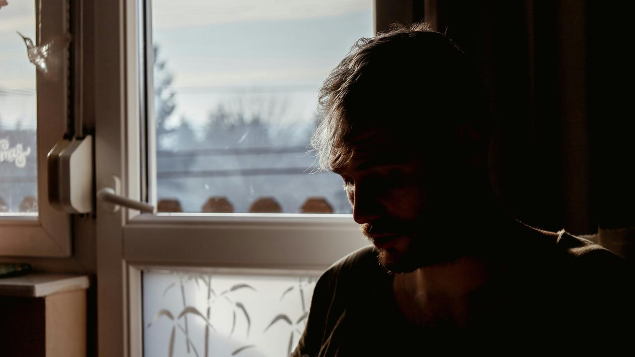 A silhouette of a man by a window.
