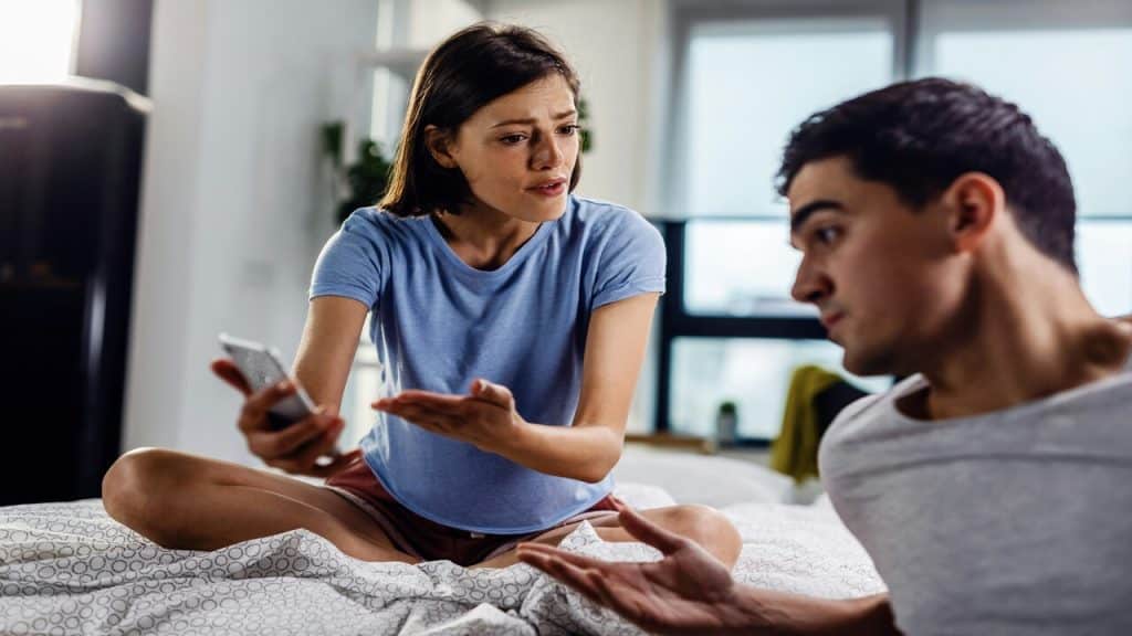 A couple having an argument while looking at a phone