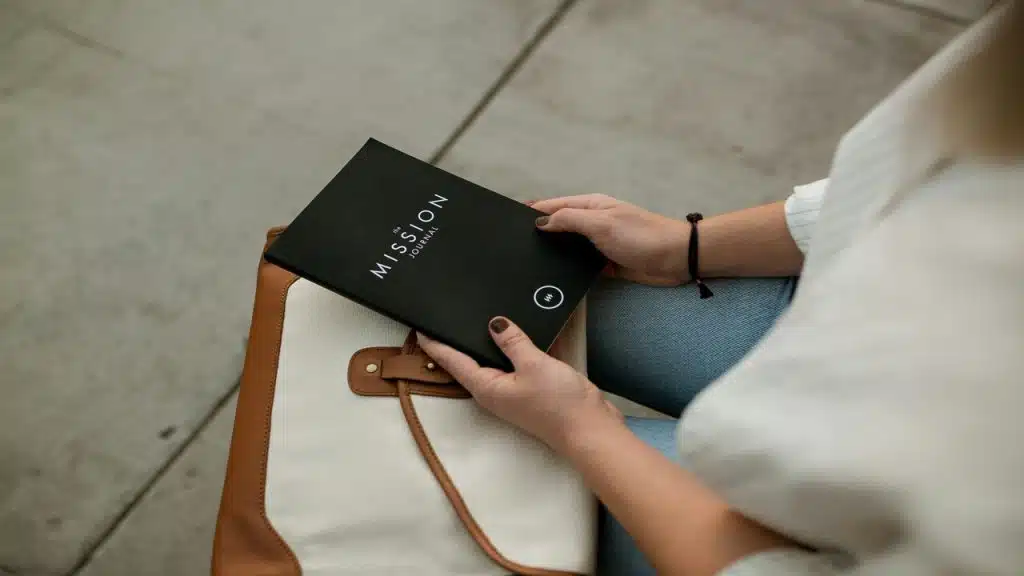 A woman holding a “mission” journal